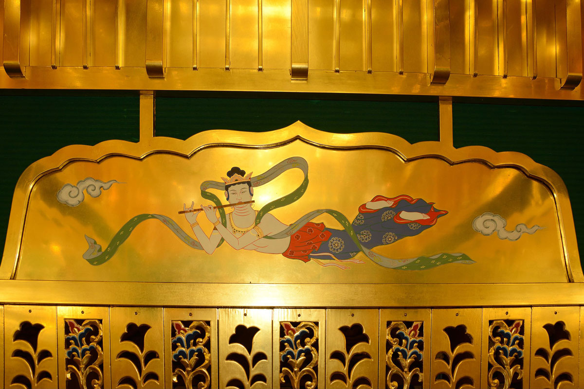 Inside the canopy, beautiful celestial maidens are dancing.