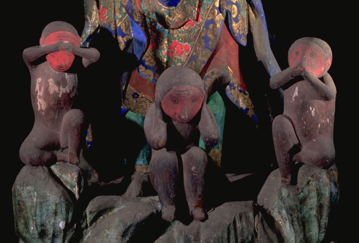 Three adorable monkeys are at his feet to play with.